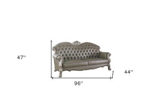 96" Bone Faux Leather Sofa with tufted back, white legs, and decorative detailing, includes toss pillows. Dimensions: 96" x 4