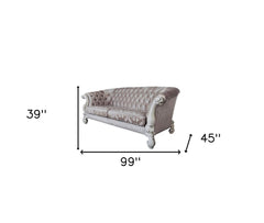 Ivory velvet damask sofa with bone legs, featuring tufted design and toss pillows, measuring 99" wide, 39" deep, and 45" high