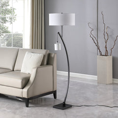 59" Matte Black Dual Arc Floor Lamp with a white drum shade, featuring a sleek design next to a modern sofa in a bright room.