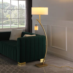 59" Gold and White Arc Floor Lamp featuring a white fabric drum shade, positioned next to a green sofa in a bright room.