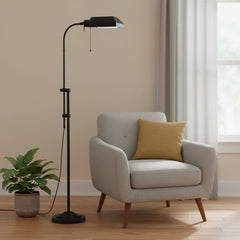 57" Bronze Metal Adjustable Floor Lamp with square bronze shade, beside a gray armchair and potted plant in a bright room.