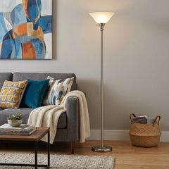 71" Nickel Torchiere Floor Lamp with clear frosted glass dome shade, placed beside a gray sofa with decorative pillows in a c