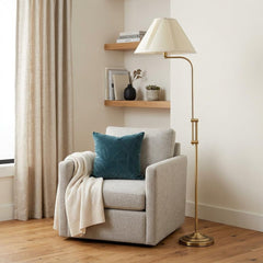 68" Bronze Adjustable Traditional Floor Lamp with Beige Empire Shade beside a cozy armchair and decorative shelves.