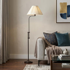 68" Bronze Adjustable Traditional Floor Lamp with Beige Empire Shade, featuring a curved arm and stylish design, placed besid