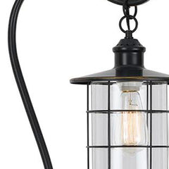 Antiqued bronze floor lamp with a lantern style, featuring a glass and metal shade and a vintage bulb. 60 inches tall.