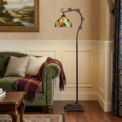 61" Bronze floor lamp featuring a green and yellow glass dome shade, set beside a green sofa with a cozy throw.