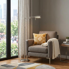 61" Nickel Metal Adjustable Swing Arm Floor Lamp with Gray Shade beside a cozy gray armchair and decorative pillow in a moder