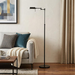 61" Bronze Adjustable Swing Arm Floor Lamp with a sleek design, positioned next to a cozy sofa and decorative throw.