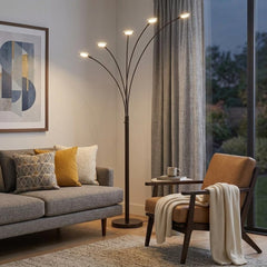 72" Bronze Five Light LED Arc Floor Lamp with curved arms, illuminating a cozy living room with a sofa and armchair.