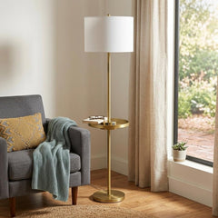 62" Brass Tray Table Floor Lamp with White Square Shade, featuring a sleek design beside a gray sofa and natural light.