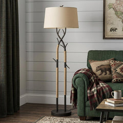 55" black metal and rope tree branch floor lamp with a tan fabric shade, complementing a cozy living room setting.