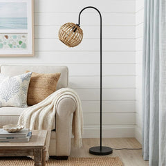 63" black traditional floor lamp with a brown globe shade, featuring a curved design beside a cozy sofa in a bright room.