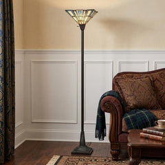 72" bronze torchiere floor lamp with gray and ivory abstract Tiffany glass shade, standing beside a cozy sofa in a living roo