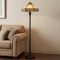 60" Bronze two-light floor lamp with an orange and ivory abstract Tiffany glass empire shade, placed beside a beige couch.