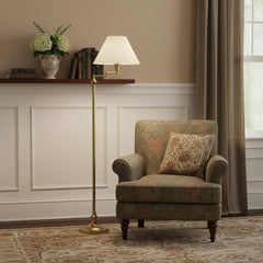 59" Bronze Metal Swing Arm Floor Lamp with Beige Fabric Empire Shade beside a green upholstered armchair in a cozy room setti