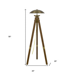 55" Brass Tripod Floor Lamp with an antiqued brass dome shade and wooden tripod legs, featuring a yellow power cord.