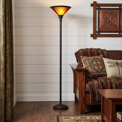 71" rusted torchiere floor lamp with a brown dome shade, standing beside a cozy sofa with patterned throw pillows and a blank
