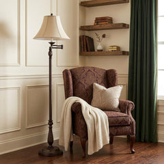 62" rusted swing arm floor lamp with champagne bell shade beside a cozy armchair, draped with a blanket, in a stylish room se