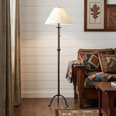 57" black traditional floor lamp with a white empire shade, featuring a classic design, placed beside a cozy sofa.