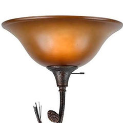 Amber torchiere floor lamp with a brown glass dome shade and an ornate base, featuring a decorative design.