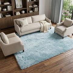 Sky blue 9' X 14' area rug in a cozy living room setting with light furniture and wooden flooring.