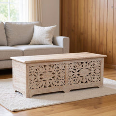 52" White Distressed Solid Wood Carved Floral Storage Ottoman with intricate floral design, placed on a light rug in a cozy l