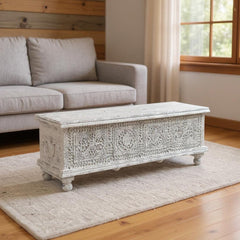 54" White Solid Wood Medallion Ottoman with intricate carvings, featuring storage space, placed on a light rug in a cozy livi