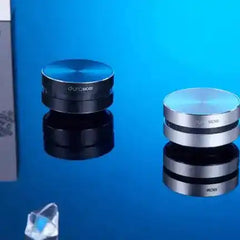 Black and silver Humbird Bone Conducting Speakers by duraMOBI on reflective blue surface, showcasing sleek portable design.