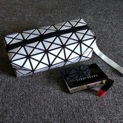 Women's diamond pattern makeup bag in Black held as a clutch – lifestyle shot for evening use