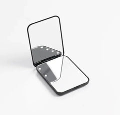 Foldable LED makeup mirror shown fully closed in compact flat-fold position